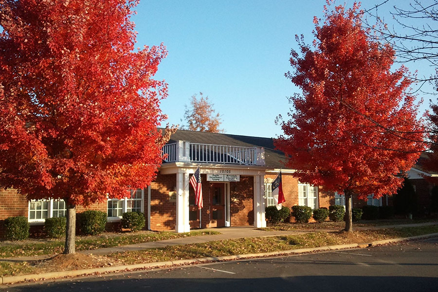 About Our Agency - View of Fogle Insurance Group Office Building in Huntersville North Carolina with Two Red Trees in the Front During the Fall